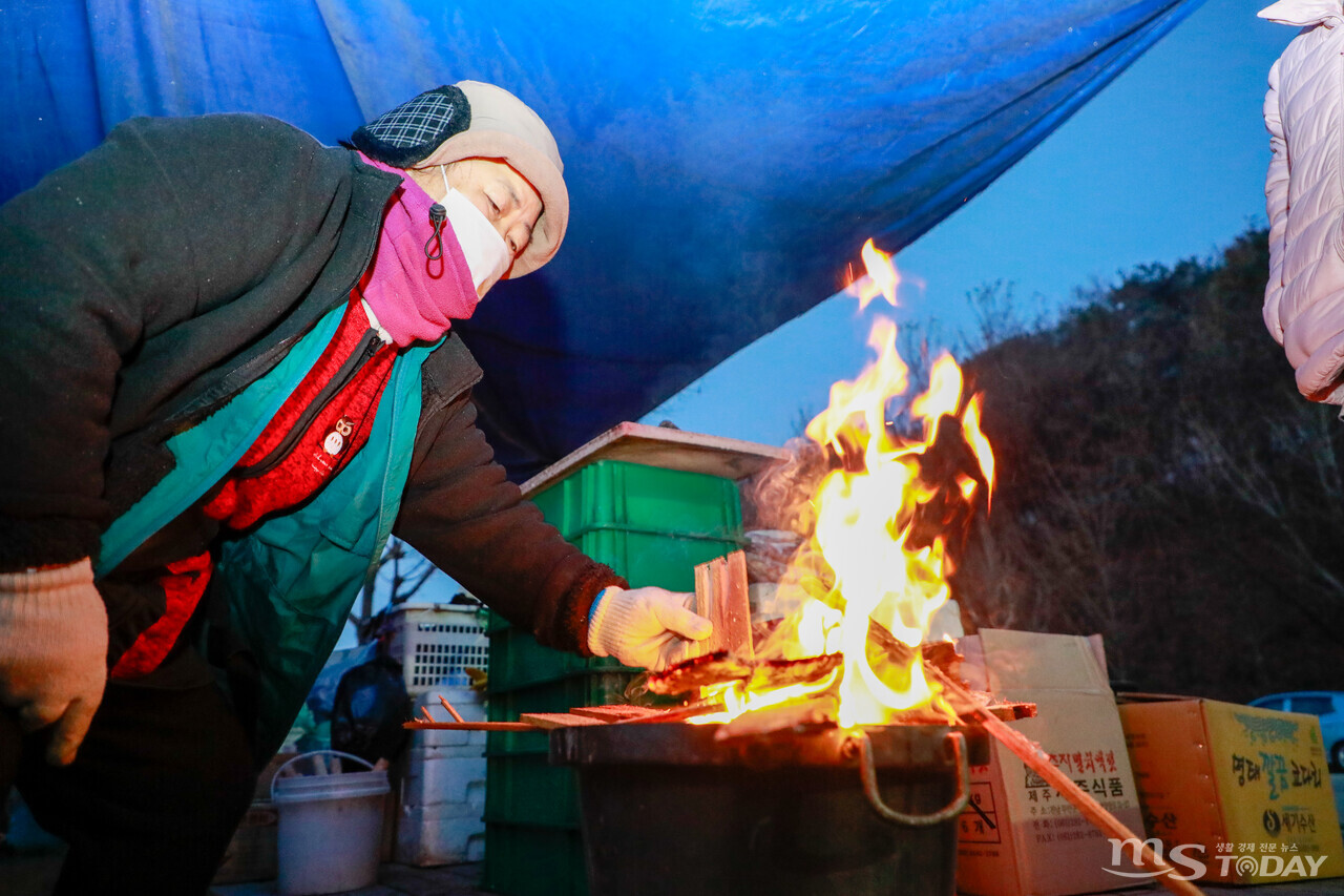 아침 최저기온 영하 2도를 기록한 15일 춘천 애막골 새벽시장에서 한 상인이 불을 피워 추위를 녹이고 있다. (사진=이정욱 기자)