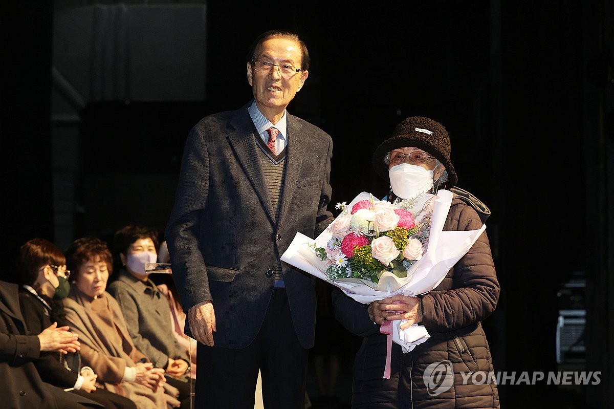 2024학년도 일성여자중고등학교 입학식에서 최고령 입학생인 김경애 할머니가 꽃다발을 받고 있다.  (사진=연합뉴스)