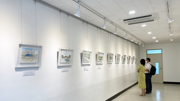 춘천시립신사우도서관 로비에 마련된 갤러리에서 원미경 작가가 전시 관람객에게 작품을 설명을 하고 있다. (사진=신초롱 기자)