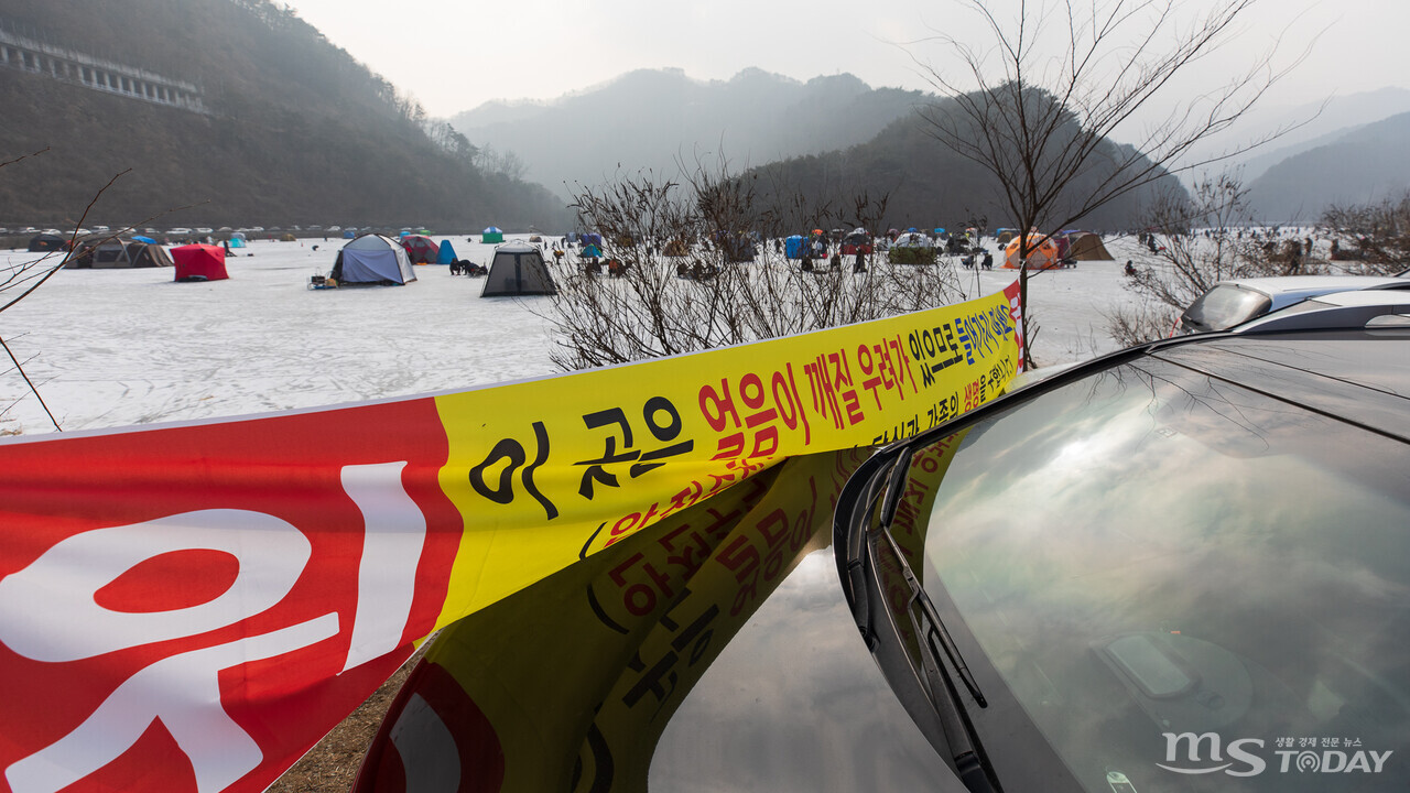 9일 춘천 오월리 낚시터에 걸린 출입금지 현수막이 불법주차 차량으로 가려져 있다. (사진=이정욱 기자)