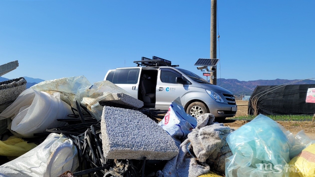 춘천 우두동 외곽의 농경지 도로에 쓰레기가 쌓여 있다. 춘천시 관계자가 인근에 설치된 이동식 CCTV를 확인하고 있다. (사진=배상철 기자)