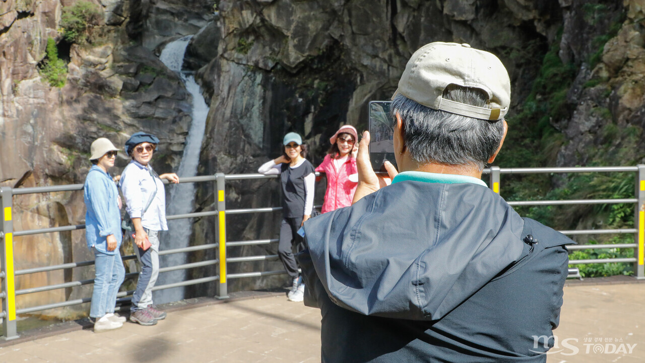 관광객들이 철원 8경 가운데 하나인 삼부연폭포를 배경으로 기념사진을 찍고 있다. 