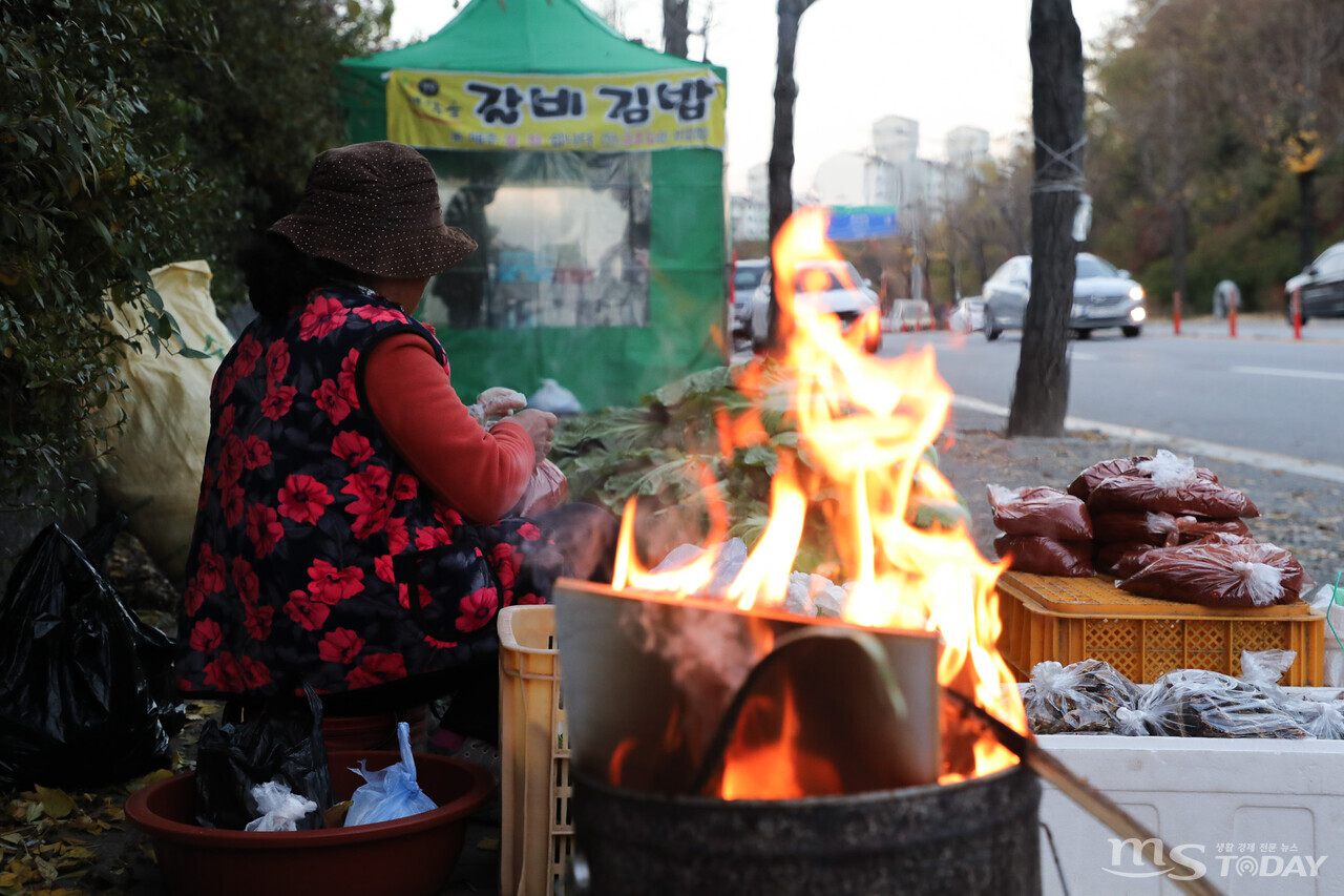 아침 최저기온이 영하 2도까지 떨어진 4일 춘천 새벽시장, 갑자기 추워진 날씨에 한 상인이 불을 지펴 추위를 견디고 있다. (사진=이정욱 기자)